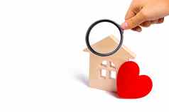放大玻璃木房子红色的心白色背景爱的关系购买房子年轻的家庭负担得起的住房家庭心理学强大的关系