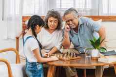 亚洲夫妇祖父母孙子玩国际象棋