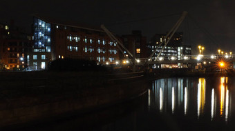 城市景观视图运河入口克莱伦斯码头区域利兹行人桥穿越水反射灯建筑晚上天空云