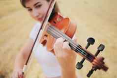 美丽的浪漫的女孩宽松的头发玩小提琴场
