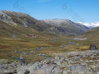 秋天视图<strong>红</strong>色的十字架旅游站山小屋建筑徒步旅行冰川斯莫斯塔<strong>布林</strong>蓝色的溪流白雪覆盖的山橙色莫斯希斯约顿海门国家公园西方挪威