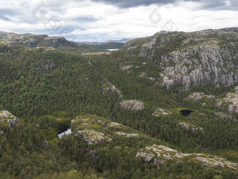 视图景观森林湖泊山徒步旅行讲坛岩巨大的悬崖著名的挪威的观点喜怒无常的天空秋天一天自然旅行背景假期徒步旅行假期概念