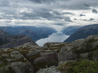 视图景观岩石简介石头利瑟峡湾徒步旅行讲坛岩巨大的悬崖著名的挪威的观点喜怒无常的天空秋天一天自然旅行背景假期徒步旅行假期概念
