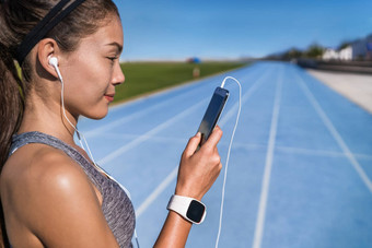 运行音乐动机女人听电话应用程序耳机跑步者智能手机体育场运行跟踪耳机移动电话准备好了运行健康的生活方式