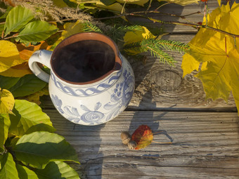 秋天生活热吸烟茶乡村白色蓝色的画陶瓷杯色彩斑斓的秋天彩色的叶子山毛榉枫木树分支机构橡木橡子难看的东西木桌子上金光