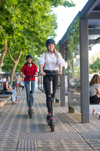 时尚的轻轻松松少年女孩骑公共租赁电摩托车城市城市环境环保现代公共城市运输