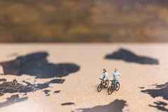 微型人旅行者骑自行车世界地图旅行