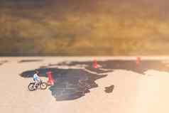 微型人旅行者骑自行车世界地图旅行