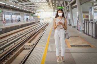 年轻的亚洲女人乘客穿外科手术面具合伙人