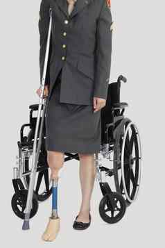 低部分女军事官拐杖站前面轮椅灰色的背景