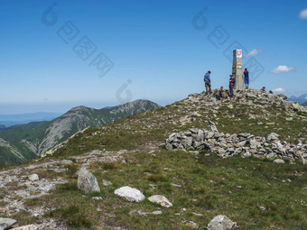 斯洛伐克西方塔特拉山山7月集团徒步旅行者人休息前巴拉内克峰西方塔特拉山山rohace全景锋利的绿色山徒步旅行小道脊夏天蓝色的天空背景