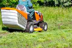 绿色草草坪上专业拖拉机剪草机清晰的阳光明媚的一天