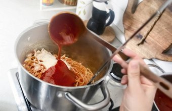 调味料锅完整的新鲜煮熟的意大利面倒番茄酱汁钢包