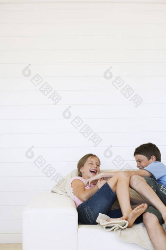 年轻的男孩女孩笑沙发上檐板房间