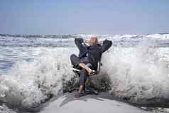 高级业务男人。坐着办公室椅子海滩溅波