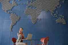 业务女人移动电话移动PC办公室世界地图墙
