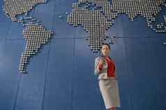 业务女人移动电话前面世界地图办公室