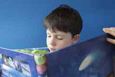 男孩阅读书在室内特写镜头