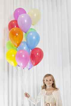 肖像年轻的生日女孩站聚会，派对气球