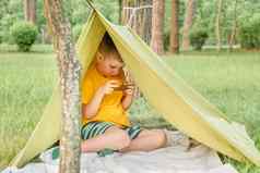 男孩玩视频游戏户外公园后院花园孩子电话帐篷年孩子有趣的自然电子学习概念孩子们小工具娱乐夏天假期