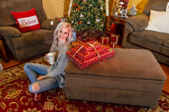可爱的年轻的金发女郎模型享受假期季节首页圣诞节树礼物