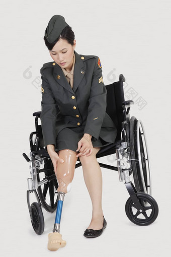 女军事官轮椅持有人工<strong>肢体</strong>灰色的背景