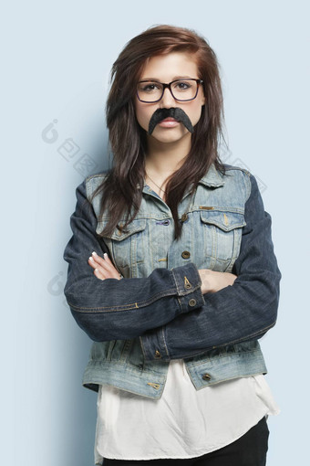 肖像年轻的女人穿眼镜假的胡子光蓝色的背景