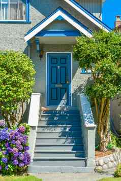 蓝色的入口通过家庭房子玄关台阶前面
