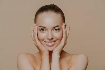 皮肤护理美概念头像美丽的快乐的女人触摸脸轻轻完美的微笑健康的皮肤清洁应用面部面具孤立的米色背景