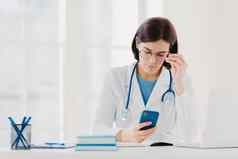 医疗技术概念集中女人医生智能手机设备检查信息互联网穿听诊器脖子大轮眼镜提出了诊所
