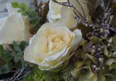 关闭白色奶油纺织玫瑰nad绿色叶子装饰花背景