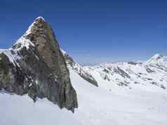 冬天景观锋利的山峰雪覆盖山坡上滑道滑雪者享受春天阳光明媚的一天滑雪度假胜地stubai格莱彻入住提洛尔奥地利阿尔卑斯山脉