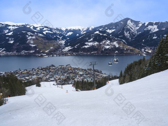 全景视图美丽的冬天风景阿尔卑斯山脉清晰的湖雪山坡上电缆车滑雪电梯小屋传统的高山小木屋村阳光明媚的一天蓝色的天空泽尔萨尔茨堡土地奥地利