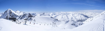 全景景观视图前怀尔德斯皮茨冬天景观雪覆盖山山坡上滑道滑雪者椅子电梯stubai格莱彻滑雪度假胜地春天阳光明媚的一天蓝色的天空背景入住提洛尔奥地利阿尔卑斯山脉