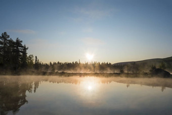 美丽的早....橙色日出湖Sjabatjakjaure阴霾雾瑞典拉普兰自然山桦木树云杉森林岩石巨石草天空云清晰的水