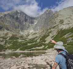 年轻的男人。徒步旅行者点山峰隆尼基盾夏天最高山山峰高基山斯洛伐克高塔特拉山湖斯卡尔纳特pleso