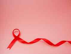 红色的丝带粉红色的背景世界艾滋病一天概念