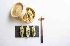 蒸饺子日本饺子饺子零食传统的木轮船黑色的石头板岩白色纹理石头背景前视图空间文本