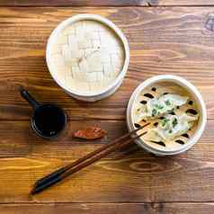 新鲜的煮熟的饺子饺子木轮船筷子我是酱汁中国人传统的厨房前视图