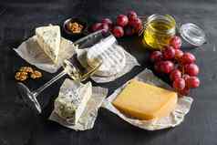 分类奶酪玻璃白色长相思酒蜂蜜坚果开胃菜选择抱怨零食集模制奶酪奶酪质新鲜的无花果黑色的背景黑板上一边视图