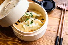 中国人零食中国人蒸饺子中国人传统的厨房概念木轮船我是酱汁筷子关闭