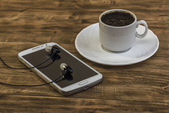 咖啡杯飞碟智能手机耳机木表面