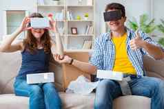 年轻的家庭玩游戏虚拟现实眼镜