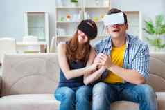 年轻的家庭玩游戏虚拟现实眼镜