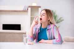 年轻的女人吸入器应对哮喘
