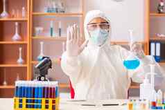 年轻的生物化学家穿保护西装工作实验室