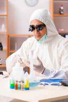年轻的生物化学家穿保护西装工作实验室