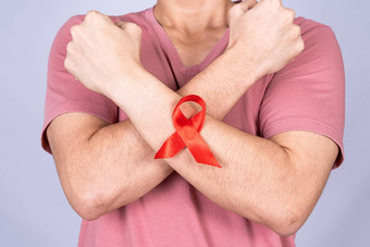红色的艾滋病意识丝带男人。手臂提高手战斗灰色背景世界艾滋病一天医疗保健医疗概念