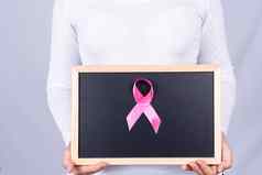 乳房癌症意识丝带黑板上持有女人医疗医疗保健广告概念