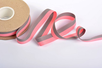 粉红色的灰色的棉花丝带卷纺织品筒子身材魁梧的磁带绳子石灰带子旋度白色背景